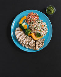 The full plate: Italian herb-roasted chicken breast with couscous salad, roasted vegetables and a pot of pesto. Serving suggestion; the box is the chicken only.
